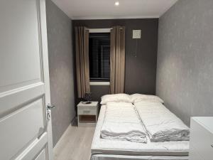 a small bedroom with a bed and a window at Sokkelleilighet in Grindheim