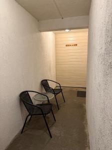 two chairs and a table in a room with a garage at Sokkelleilighet in Grindheim +2 photos