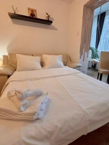 a large white bed with two towels on it at Sleep & Go Floreasca Green in Bucharest