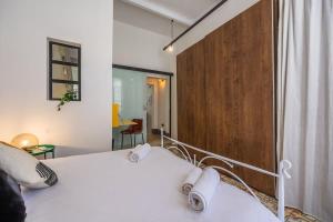a bedroom with a white bed with a wooden wall at Birkirkara Typical 2BDR Townhouse in Birkirkara