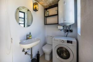 a small bathroom with a sink and a washing machine at Birkirkara Typical 2BDR Townhouse in Birkirkara