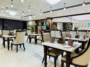 a dining room with tables and chairs in a restaurant at Hotel Avnish Near To Tajmahal in Agra