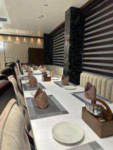a long table with chairs and plates on it at Hotel Avnish Near To Tajmahal in Agra