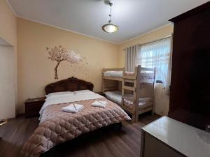 a bedroom with a bed and a tree on the wall at Blissful Hostel in Shkodër