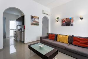 a living room with a couch and a table at Four Bedroom Typical Maltese Townhouse - One Minute Away From The Seafront in Sliema
