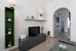 a living room with a television and a fireplace at Four Bedroom Typical Maltese Townhouse - One Minute Away From The Seafront in Sliema