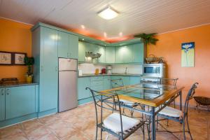 a kitchen with blue cabinets and a table and chairs at Casa Julia Finca Montimar in Guía de Isora