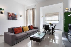 a living room with a couch and a table at Four Bedroom Typical Maltese Townhouse - One Minute Away From The Seafront in Sliema