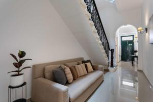 a living room with a couch and a staircase at Four Bedroom Typical Maltese Townhouse - One Minute Away From The Seafront in Sliema +23 photos