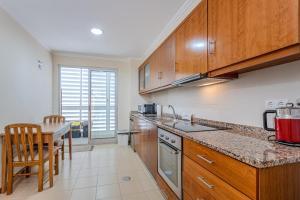 a kitchen with wooden cabinets and a counter top at GuestReady - Santo Amaro apartment in Vila Franca do Campo