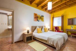 a bedroom with a large bed with yellow walls at Casa Julia Finca Montimar in Guía de Isora +18 photos