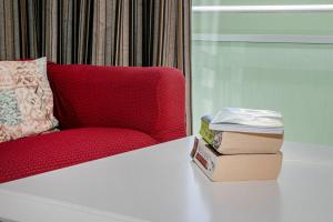two books sitting on a table next to a red couch at GuestReady - Santo Amaro apartment in Vila Franca do Campo +26 photos