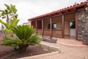 a house with a palm tree in front of it at Casa Julia Finca Montimar in Guía de Isora