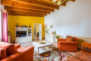 a living room with orange furniture and a tv at Casa Julia Finca Montimar in Guía de Isora