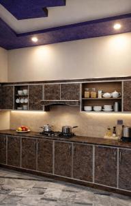 a kitchen with a counter with pots and pans at Hotel Red Roof & Restaurant in Abbottabad
