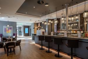 a bar in a restaurant with chairs and a counter at Premier Inn Hannover City Centre in Hannover