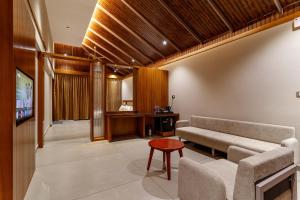 a living room with a couch and a table at Vynza Resort Vythiri in Vythiri