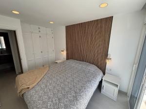 a bedroom with a bed and a wooden wall at Vista Mar in Mogán +7 photos