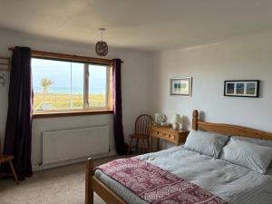a bedroom with a bed and a window and a desk at Buttof Lewis B&B in Lionel