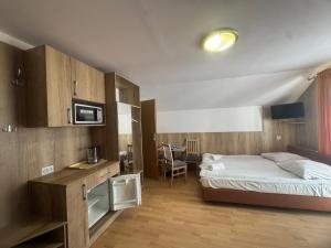 a bedroom with a bed and a desk with a microwave at Pokoje Gościnne & Apartamenty Przemyk in Rewa