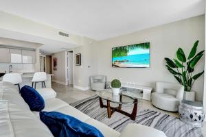 a living room with a white couch and a table at Beachwalk Resort in Hallandale Beach