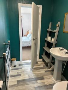 a bathroom with a sink and a door leading to a bedroom at Buttof Lewis B&B in Lionel +28 photos