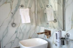a bathroom with a sink and a toilet and a mirror at Hotel Sunrise N Resorts in Nagpur +23 photos