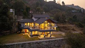a house on a hill with its lights on at Summerfield Manor 5 Bedroom Garden Estate in Bhīm Tāl