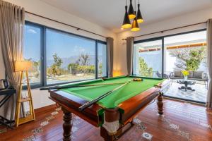 a room with a pool table and large windows at Summerfield Manor 5 Bedroom Garden Estate in Bhīm Tāl