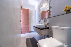 a bathroom with a toilet and a sink and a mirror at Summerfield Manor 5 Bedroom Garden Estate in Bhīm Tāl +33 photos