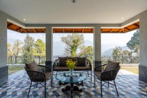 a living room with a glass coffee table and chairs at Summerfield Manor 5 Bedroom Garden Estate in Bhīm Tāl