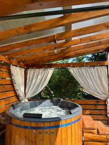a hot tub on a deck with curtains at Agroturystyka Pod Lasem na Roztoczu in Sochy