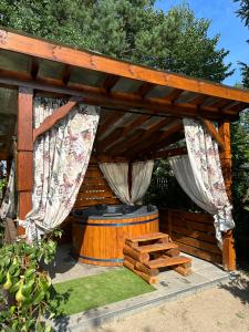 a wooden gazebo with a hot tub and a barrel at Agroturystyka Pod Lasem na Roztoczu in Sochy