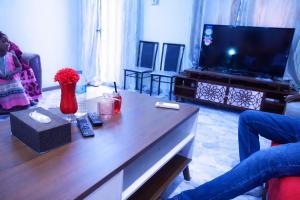 a living room with a coffee table and a tv at Villa Sahel in Niamey