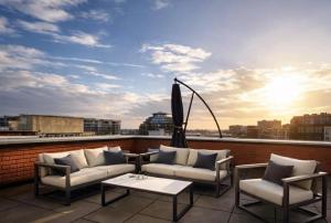 a balcony with a couch and chairs on a roof at The Residence Enschede in Enschede