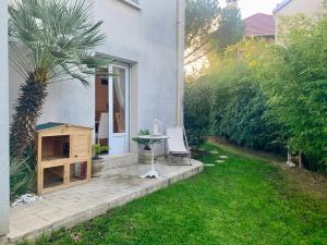 a patio with a table and a chair in a yard at belle maison 3000 m de Paris in Cachan