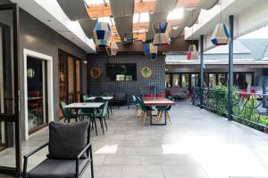 a restaurant with tables and chairs and windows at Cu Guest House in Phalaborwa