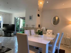 a dining room with a white table and chairs at belle maison 3000 m de Paris in Cachan