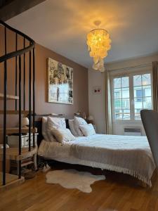 a bedroom with a bed and a chandelier at belle maison 3000 m de Paris in Cachan