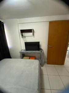 a room with a bed and a desk with a laptop at Apartamento 2 quartos West Flat in Mossoró +17 photos