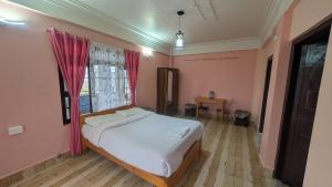 a bedroom with a bed in a room with pink walls at Mebaker View Inn in Shillong