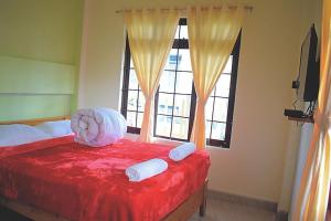 a bedroom with a red bed and a window at Mebaker View Inn in Shillong