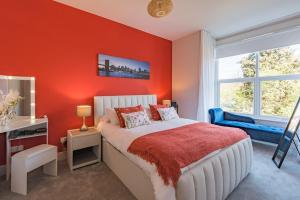 a bedroom with orange walls and a bed and a window at Folkestone Apartments in Folkestone