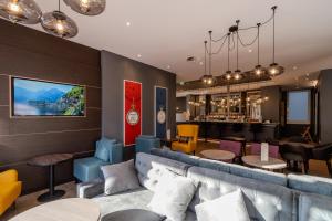 a restaurant with a couch and tables and a bar at Premier Inn Hannover City Centre in Hannover
