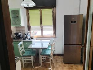 a kitchen with a table and chairs and a refrigerator at home sweet home in Buia