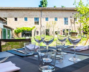 a table with wine glasses sitting on top of it at Demeures et Châteaux l'Abbaye Caladoise in Villefranche-sur-Saône +19 photos