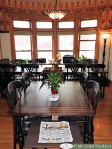 uma sala de jantar com mesas, cadeiras e janelas em Champaign Garden Inn em Champaign