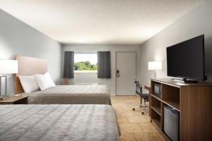 a hotel room with two beds and a flat screen tv at Home Inn & Suites in Orlando +12 photos
