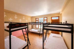 a room with three bunk beds in a room at Yellowjackets Hostel Tosh in Tosh