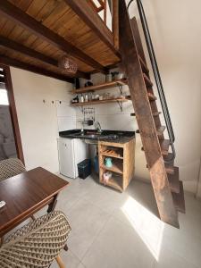 a kitchen with a table and a spiral staircase at Casaboa Apartamentos Passarela in Itacaré